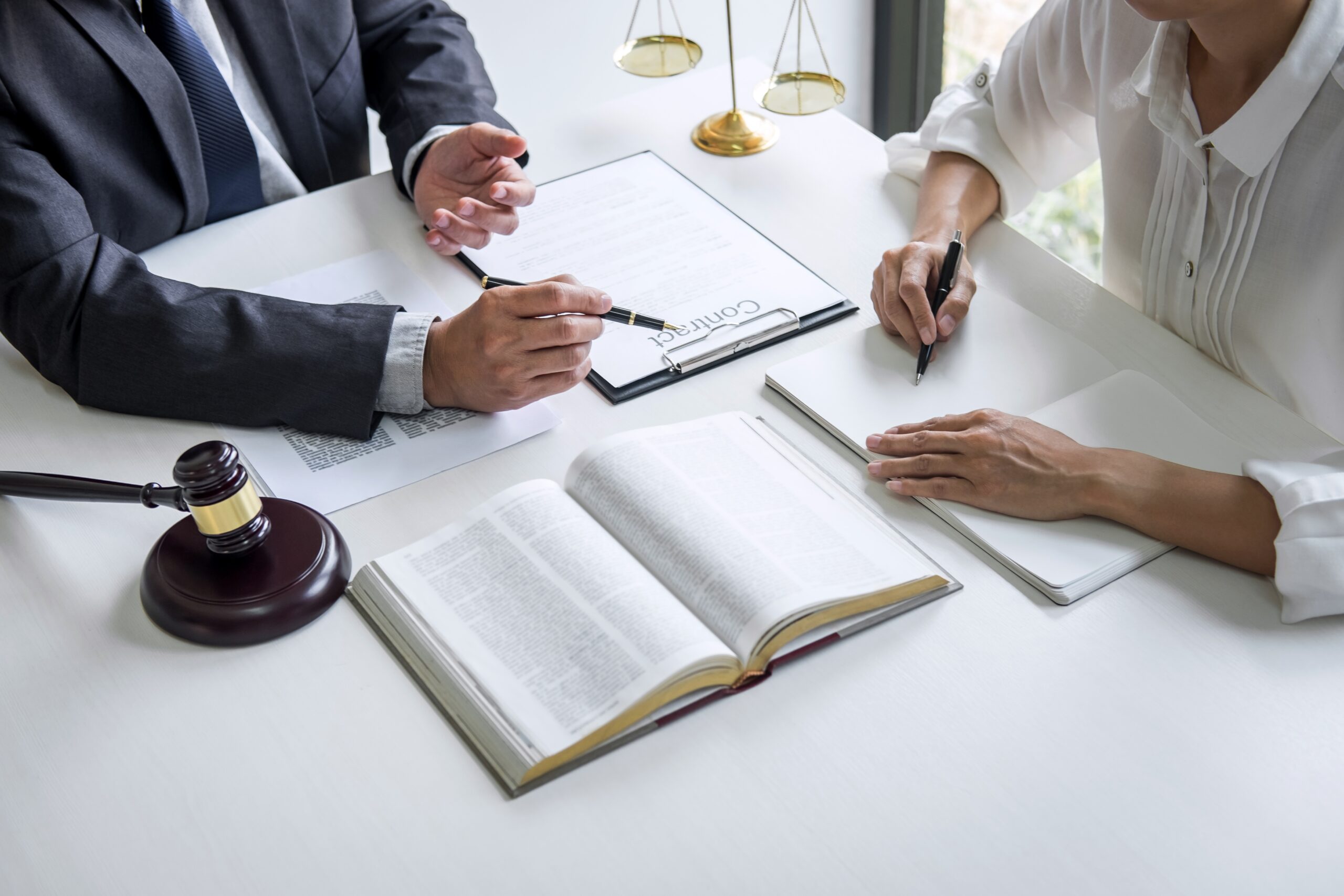 Two professionals reviewing legal documents together at a consultation table